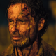 A bloodied, bandaged Rick Grimes stares ahead, dead-eyed.